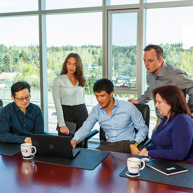 Diverse group of employees, gathered at a boardroom table