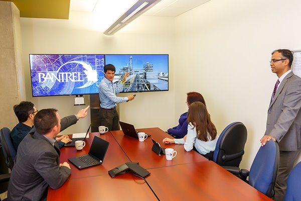 Diverse group of employees, gathered at a boardroom table